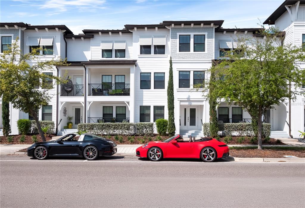 A black Porsche and a red Porsche are parked in front of white townhouses — 5351 BRIDGE STREET UNIT 49, TAMPA, FL