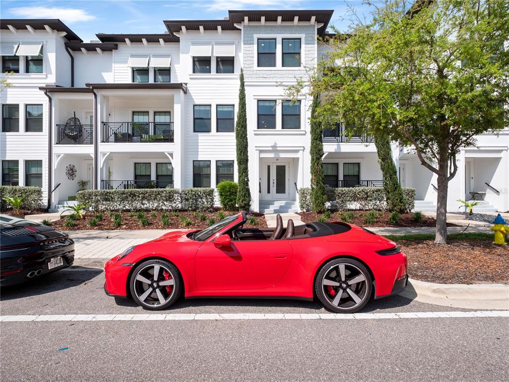 A red Porsche convertible is parked in front of a modern white multi-story townhouse — 5351 BRIDGE STREET UNIT 49, TAMPA, FL