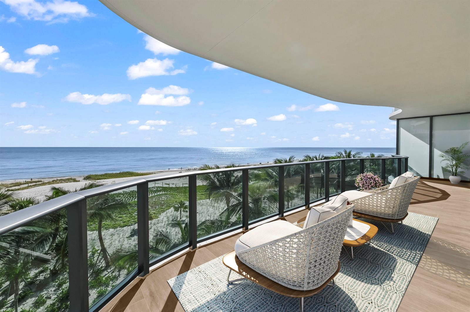 A balcony with modern lounge chairs overlooks a sandy beach and the ocean — 900 N Ocean Boulevard # 406, Pompano Beach FL 33062, POMPANO BEACH, FL
