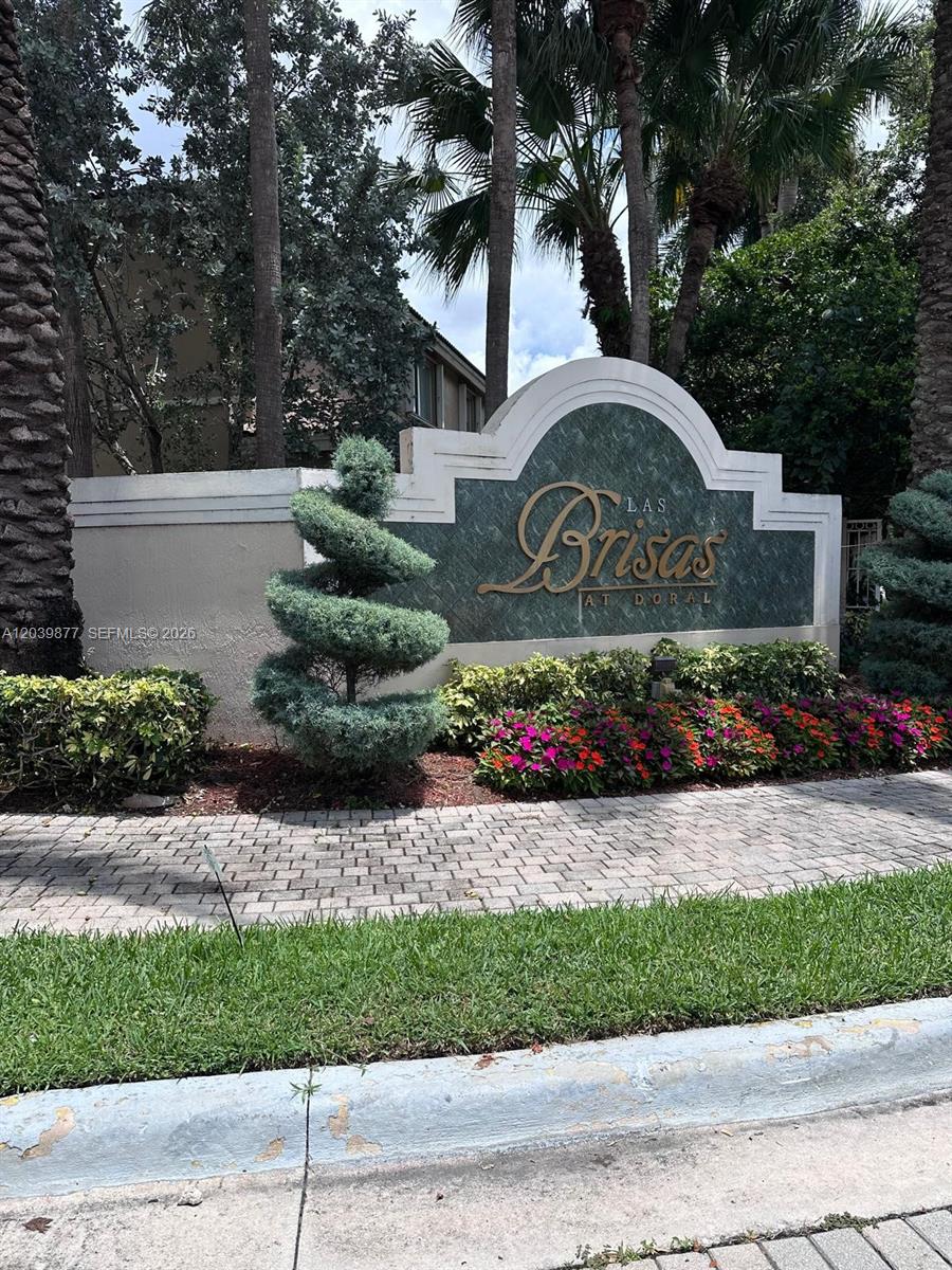 A stone monument sign for Las Brisas at Doral sits in a landscaped garden — 5791 NW 116th Ave # 101, Doral FL 33178, DORAL, FL