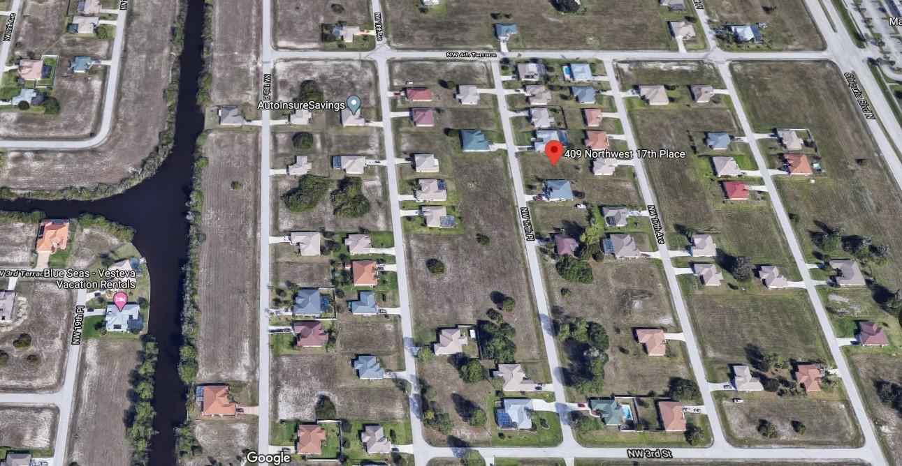 This is an aerial map view of a residential neighborhood with scattered single-family homes — 409 NW 17th Place, FL 33993, FL
