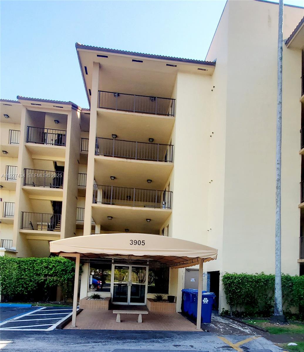 The exterior of a multi-story apartment building features a covered entrance with a tan awning — 3905 N Nob Hill Rd # 510, Sunrise FL 33351, SUNRISE, FL