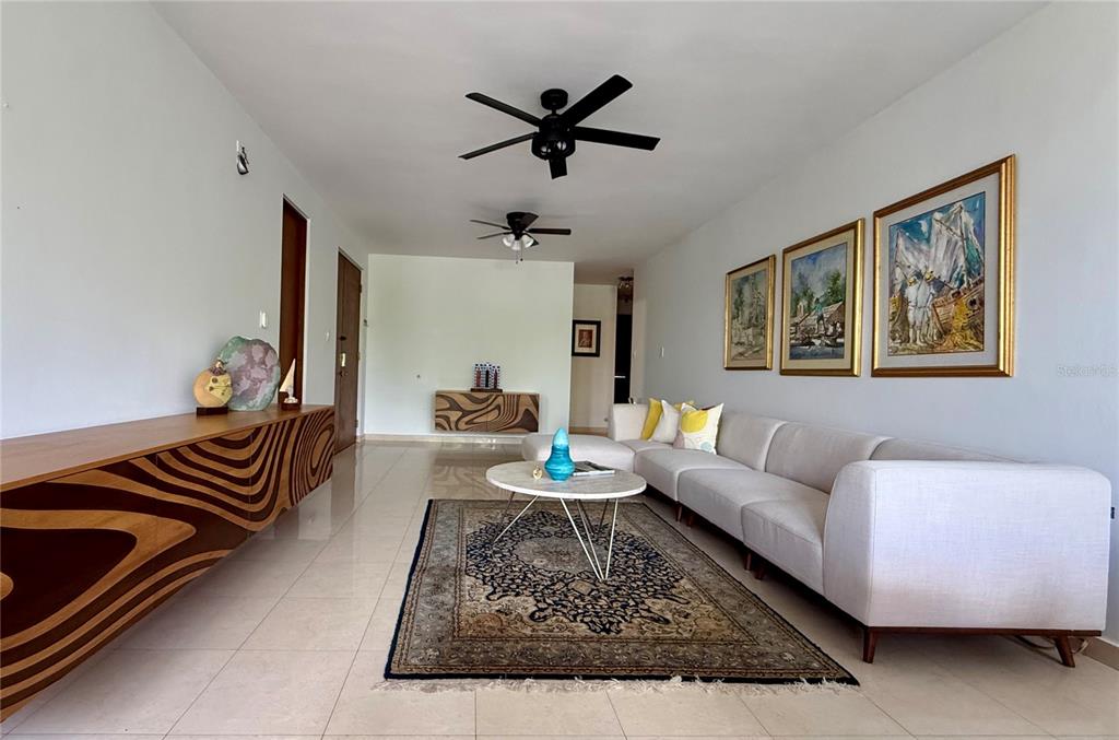A living room features a white sectional sofa, a patterned area rug, and two wooden consoles — 1 AVENIDA PALMA REAL UNIT 404, GUAYNABO, PR