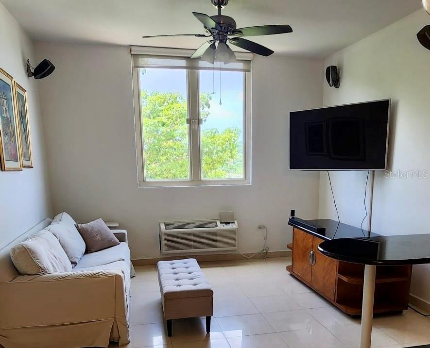 A living room features a sofa, a television on a stand, and a ceiling fan — 1 AVENIDA PALMA REAL UNIT 404, GUAYNABO, PR