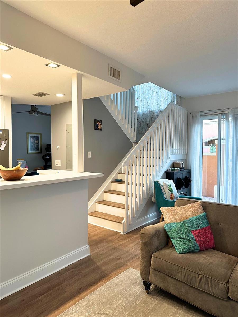 A living room features a staircase, a kitchen breakfast bar, and a sliding glass door — 2319 Clipper Place # 4510, Dania Beach FL 33312, DANIA BEACH, FL