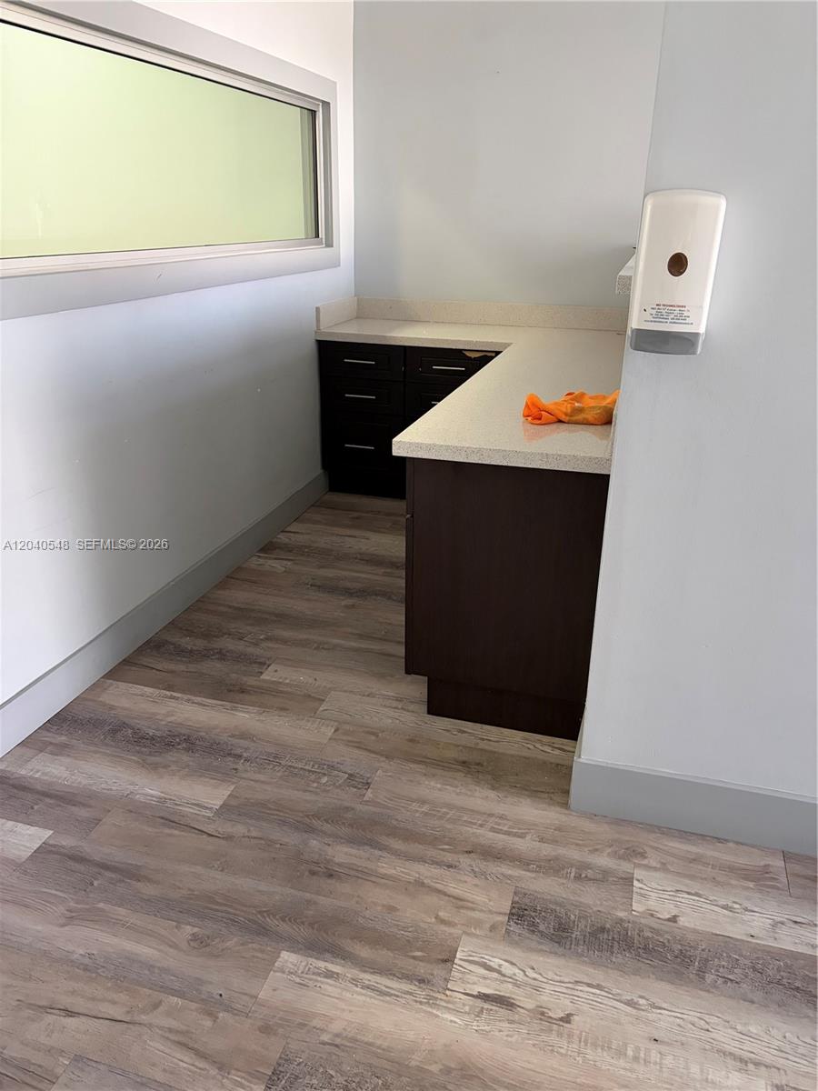 A small office area features dark wood cabinets, a light countertop, and wood-look flooring — 285 NW 27th Ave, Miami FL 33125, MIAMI, FL