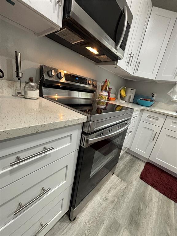 A kitchen features white cabinets, stainless steel appliances, and light-colored quartz countertops — 13849 SW 105TH PLACE, DUNNELLON, FL