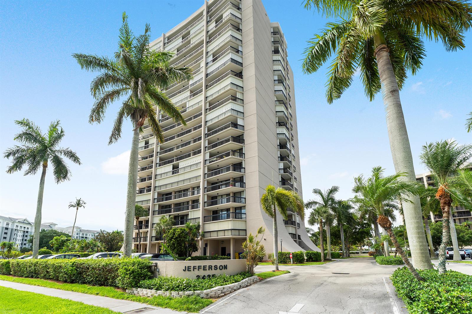 A tall residential high-rise building stands surrounded by palm trees and a paved driveway — 2425 Presidential Way, West Palm Beach FL 33401, WEST PALM BEACH, FL