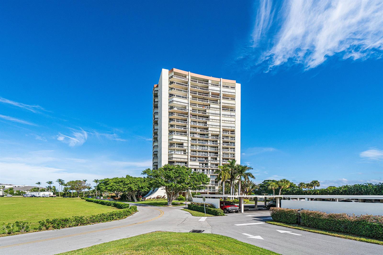 A tall residential apartment building stands behind a paved driveway and a grassy lawn — 2425 Presidential Way, West Palm Beach FL 33401, WEST PALM BEACH, FL