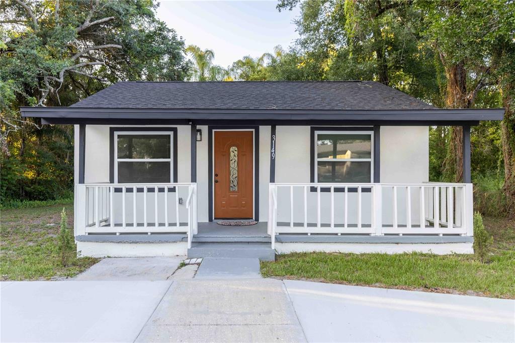 A small, single-story house with a white exterior, dark trim, and a front porch — 3149 W WASHINGTON STREET, ORLANDO, FL