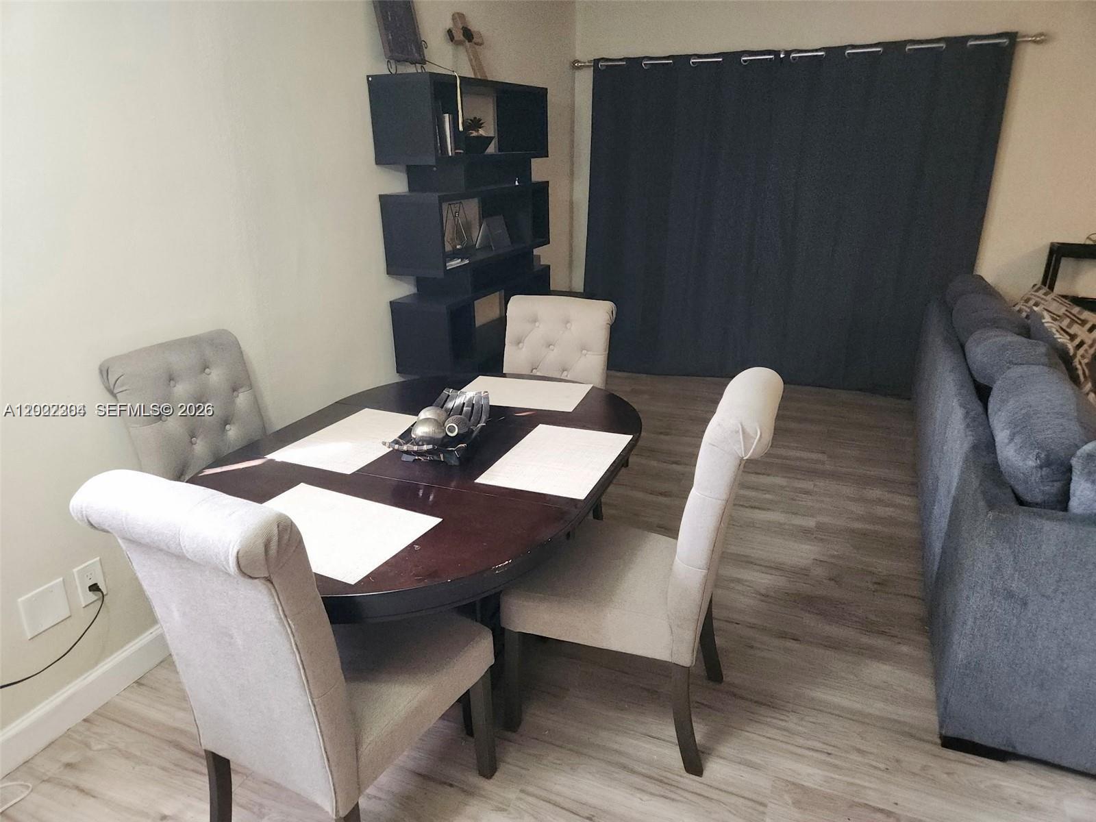A dining area features a dark wood oval table, four upholstered chairs, and a wall shelf — 4851 NW 11th Ct, Lauderhill FL 33313, LAUDERHILL, FL