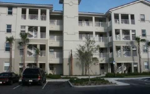 A multi-story apartment building exterior features balconies, stairwells, and a parking lot in front — 75 RIVERVIEW BEND S UNIT 1642, PALM COAST, FL