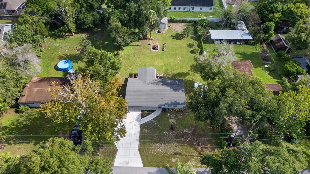 An aerial view shows a house with a gray roof, concrete driveway, and large backyard — 1146 DONALD AVENUE, ALTAMONTE SPRINGS, FL