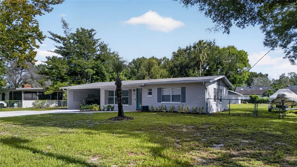 A single-story gray house with a carport and a fenced yard under a blue sky — 1146 DONALD AVENUE, ALTAMONTE SPRINGS, FL
