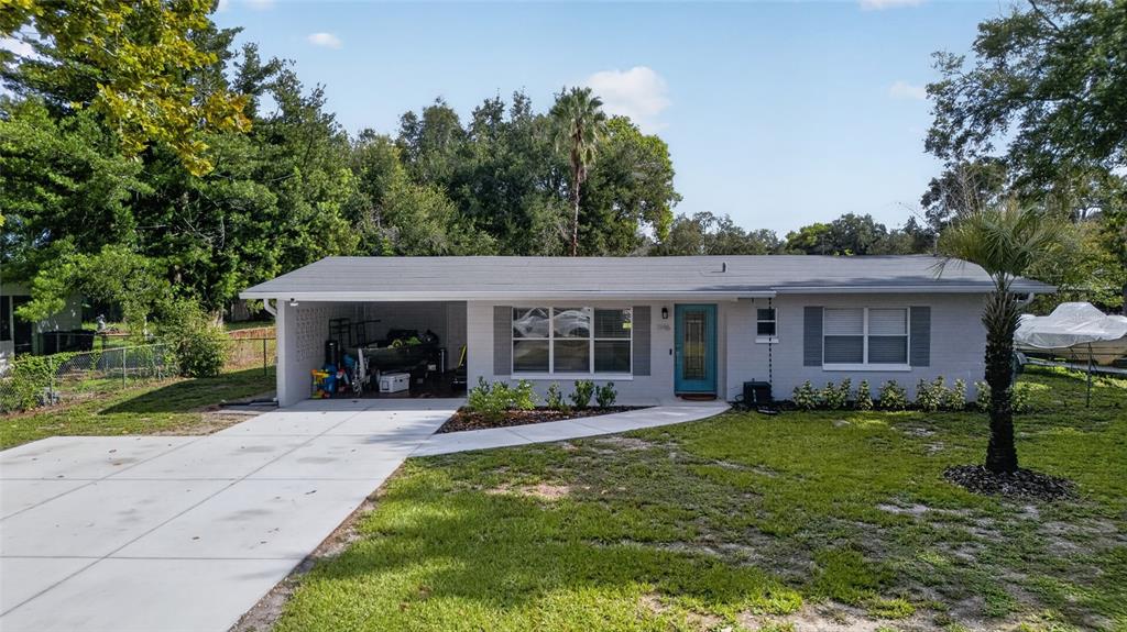 A single-story gray house with a carport, a teal front door, and a concrete driveway — 1146 DONALD AVENUE, ALTAMONTE SPRINGS, FL
