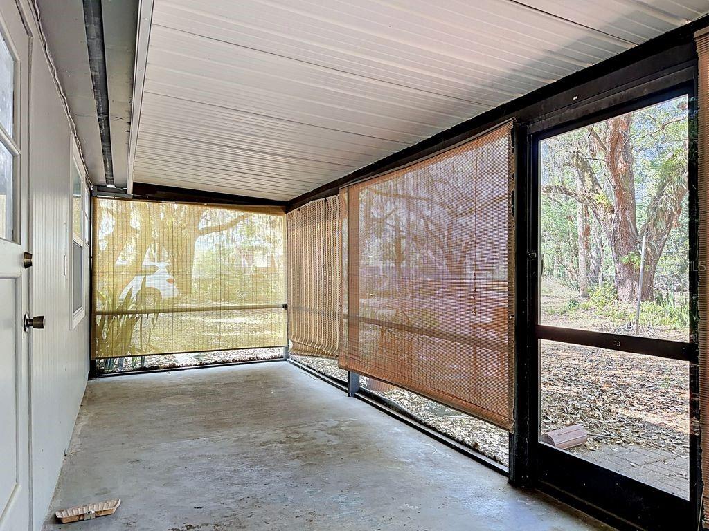 A screened-in porch with concrete flooring, a white ceiling, and bamboo roll-up shades — 3508 ROUSE ROAD, ORLANDO, FL