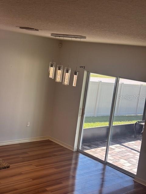 A dining area with wood-look flooring, a modern pendant light fixture, and a sliding glass door — 32762 PEZ LANDING LANE, WESLEY CHAPEL, FL