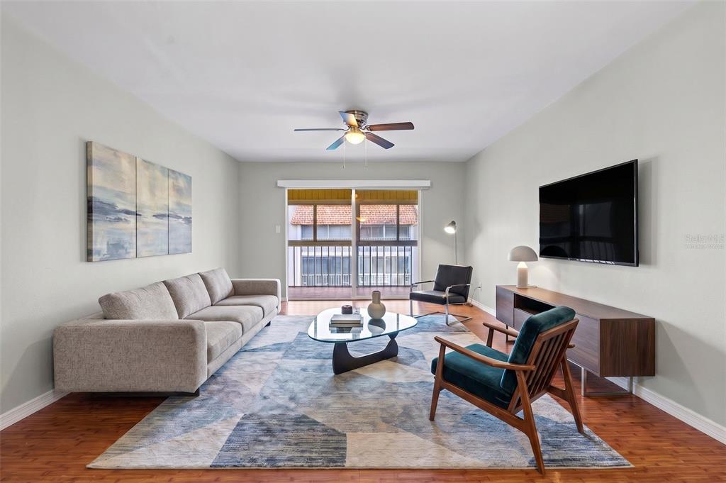 A dining room features a wooden table, four gray chairs, and a modern pendant light — 1310 GLEN OAKS DRIVE E UNIT 383E, SARASOTA, FL
