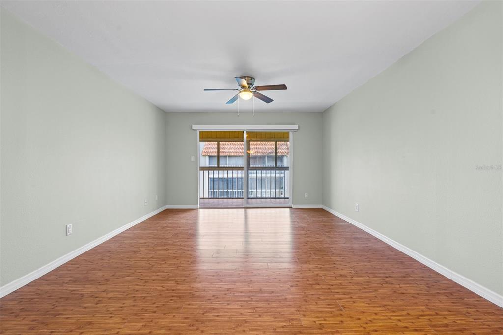 An empty dining room features light green walls, wood-look flooring, and a central pendant light — 1310 GLEN OAKS DRIVE E UNIT 383E, SARASOTA, FL