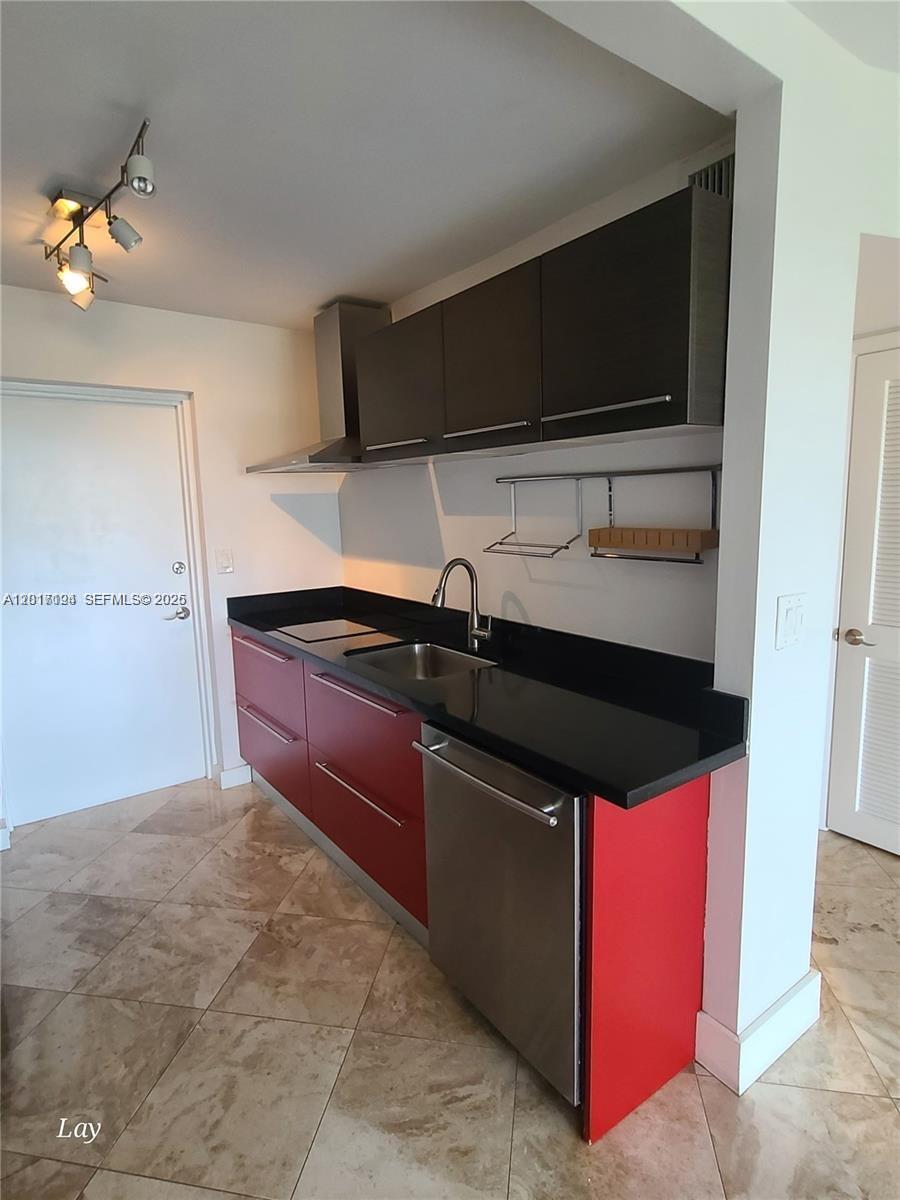A kitchen features red lower cabinets, dark upper cabinets, black countertops, and stainless steel appliances — NORTH MIAMI BEACH, FL