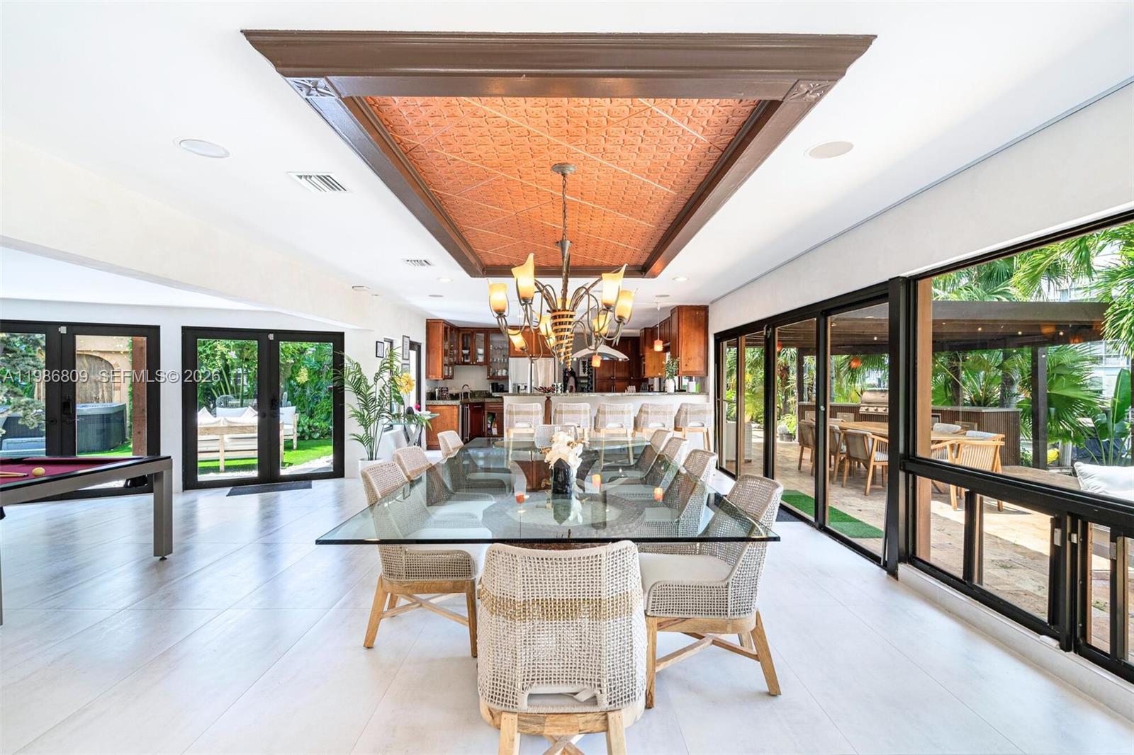 A dining room features a glass table, woven chairs, and a decorative copper-toned ceiling inlay — 1675 Coral Gardens Dr, Wilton Manors FL 33334, WILTON MANORS, FL