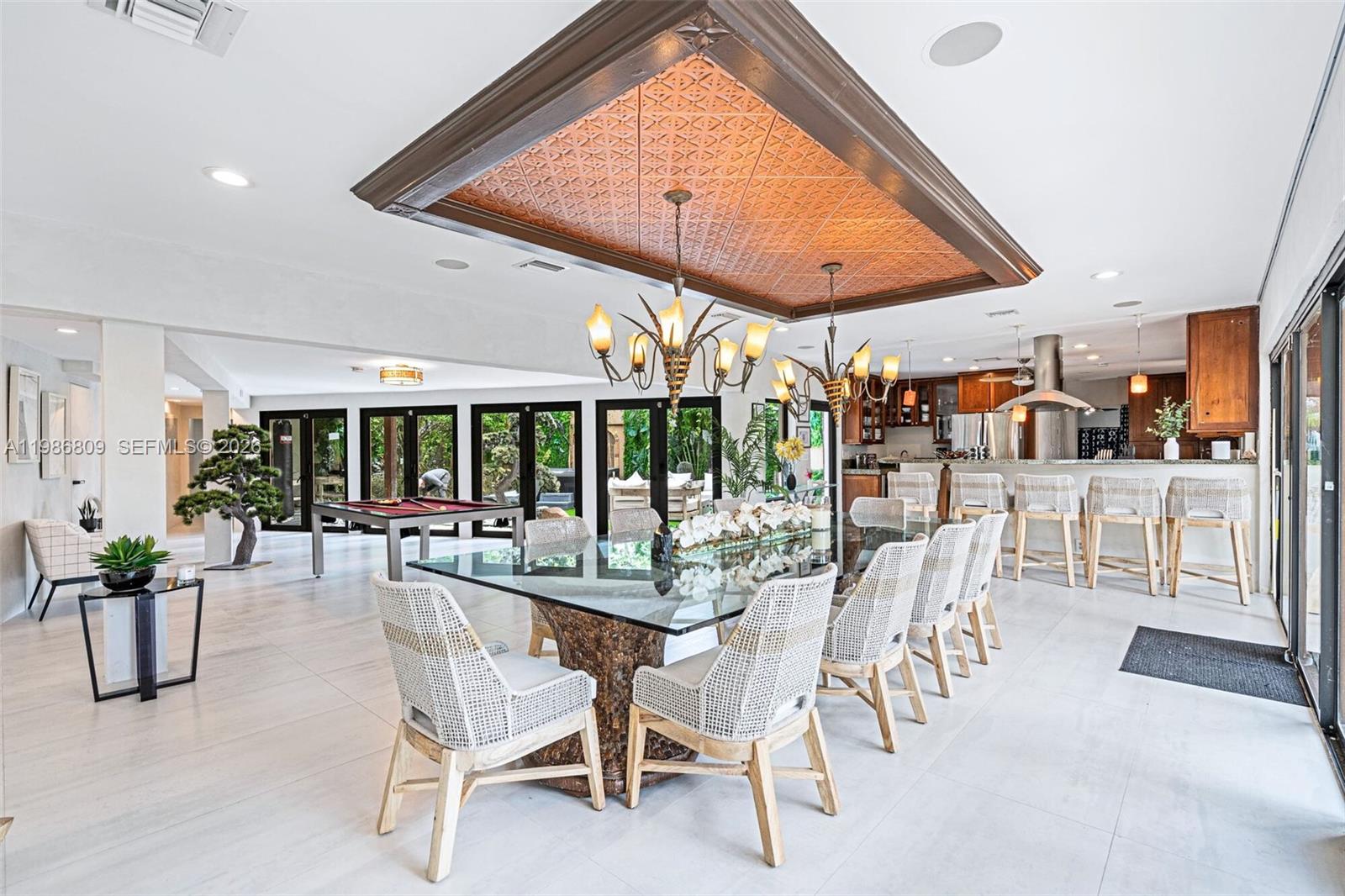 A dining room features a glass table, woven chairs, and a decorative copper ceiling inlay — 1675 Coral Gardens Dr, Wilton Manors FL 33334, WILTON MANORS, FL
