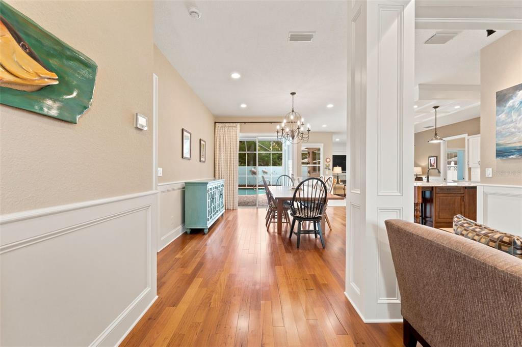 A view from a hallway looking into a dining room with hardwood floors and pool access — 2407 DANA DRIVE, SAFETY HARBOR, FL