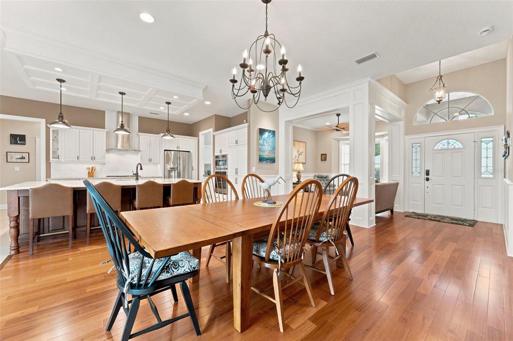 A dining area with a wooden table and chairs sits adjacent to an open-concept kitchen — 2407 DANA DRIVE, SAFETY HARBOR, FL