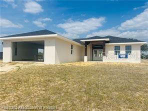 A newly constructed single-story house with a two-car garage and a light-colored stucco exterior — 4298 N COURSE LANE, AVON PARK, FL
