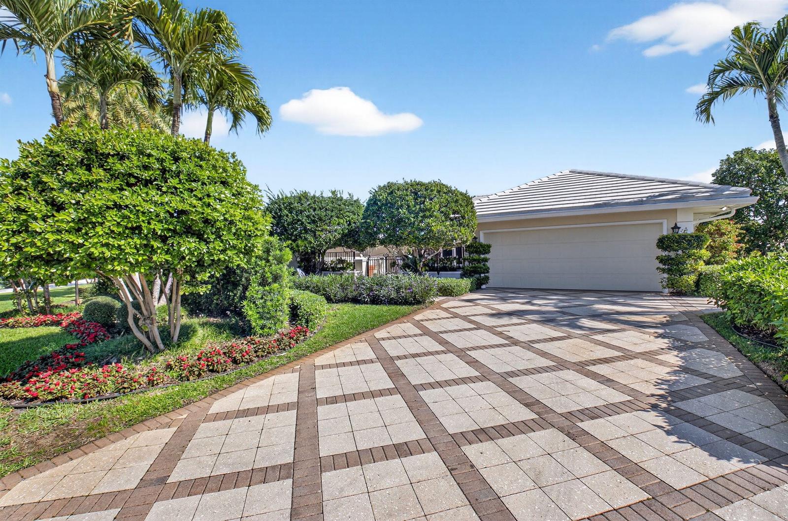 A paved driveway leads to a garage in front of a house with palm trees — 11740 N Lake Drive, Boynton Beach FL 33436, BOYNTON BEACH, FL
