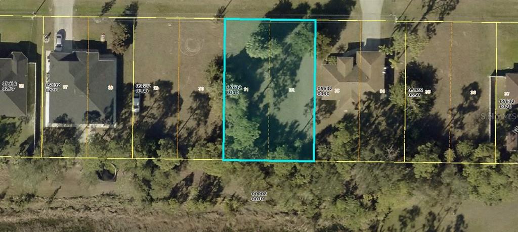 This aerial map shows a vacant residential lot highlighted in blue between two existing houses — 1814 NE 33RD STREET, CAPE CORAL, FL