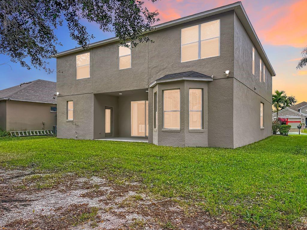 The rear exterior of a two-story house with a covered patio and a bay window — 15612 MONTESINO DRIVE, ORLANDO, FL