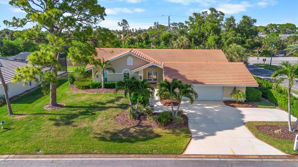 A single-story house with a tiled roof, beige stucco exterior, and a concrete driveway — 204 WINDWARD DRIVE, OSPREY, FL
