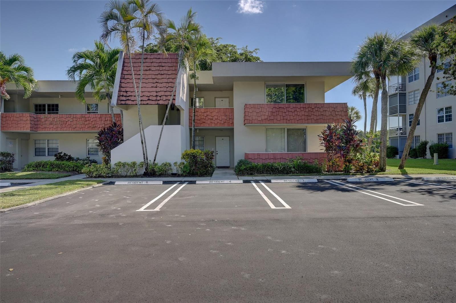 A living room with beige sofas, a glass coffee table, and a red patterned rug — 823 Cypress Boulevard # 201, Pompano Beach FL 33069, POMPANO BEACH, FL