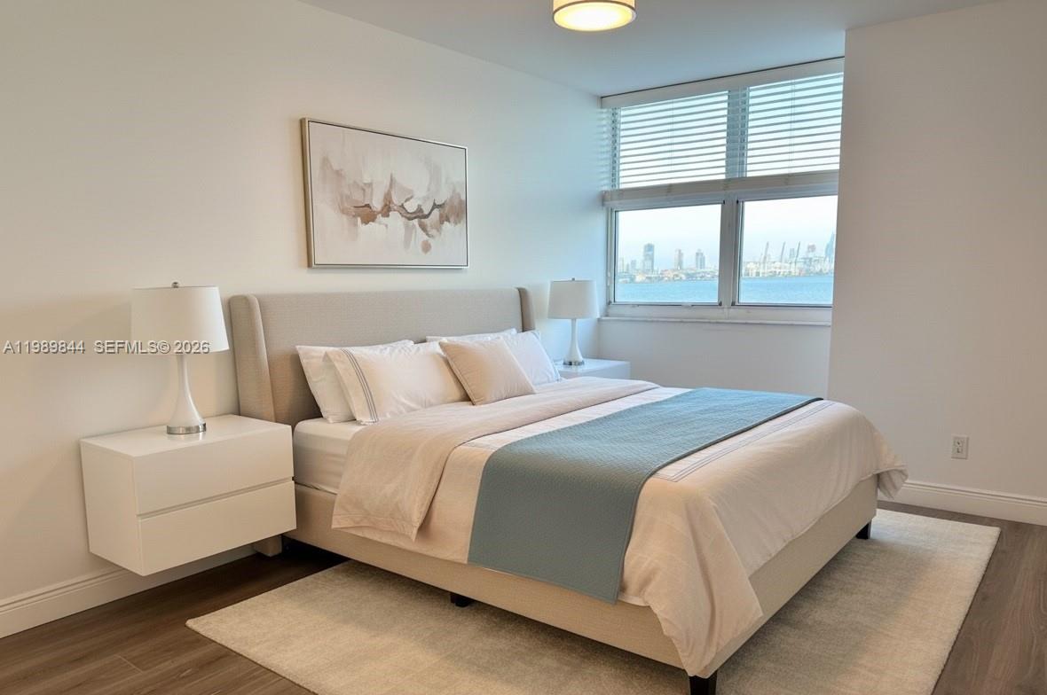 A bedroom features a bed with a blue runner, two white nightstands, and a waterfront view — 770 Claughton Island Dr # 1216, Miami FL 33131, MIAMI, FL