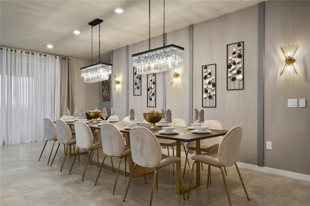 A dining room features a long table, ten upholstered chairs, and two rectangular crystal chandeliers — 3715 LANA AVENUE, DAVENPORT, FL