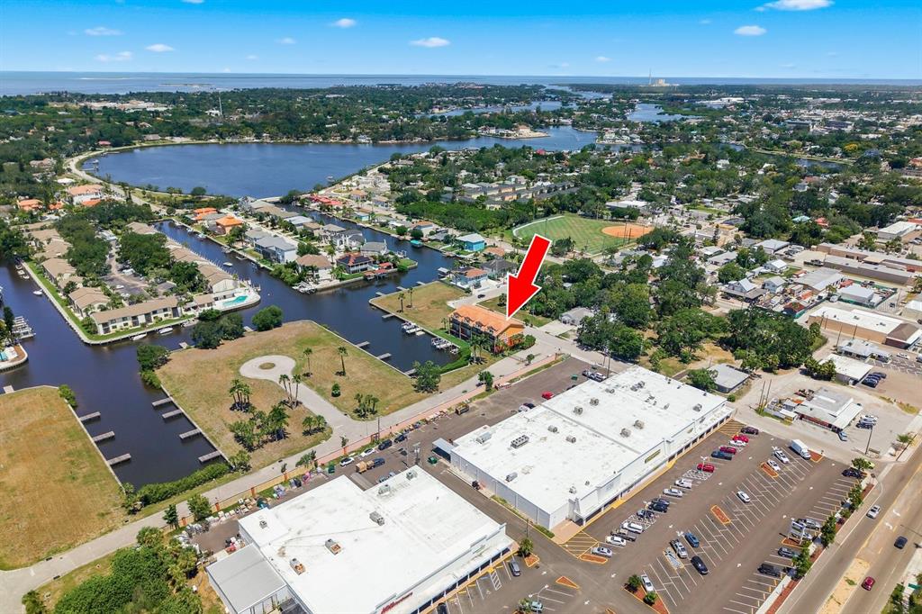 An aerial view shows a multi-story building near a canal and a large parking lot — 47 W MORGAN STREET, TARPON SPRINGS, FL