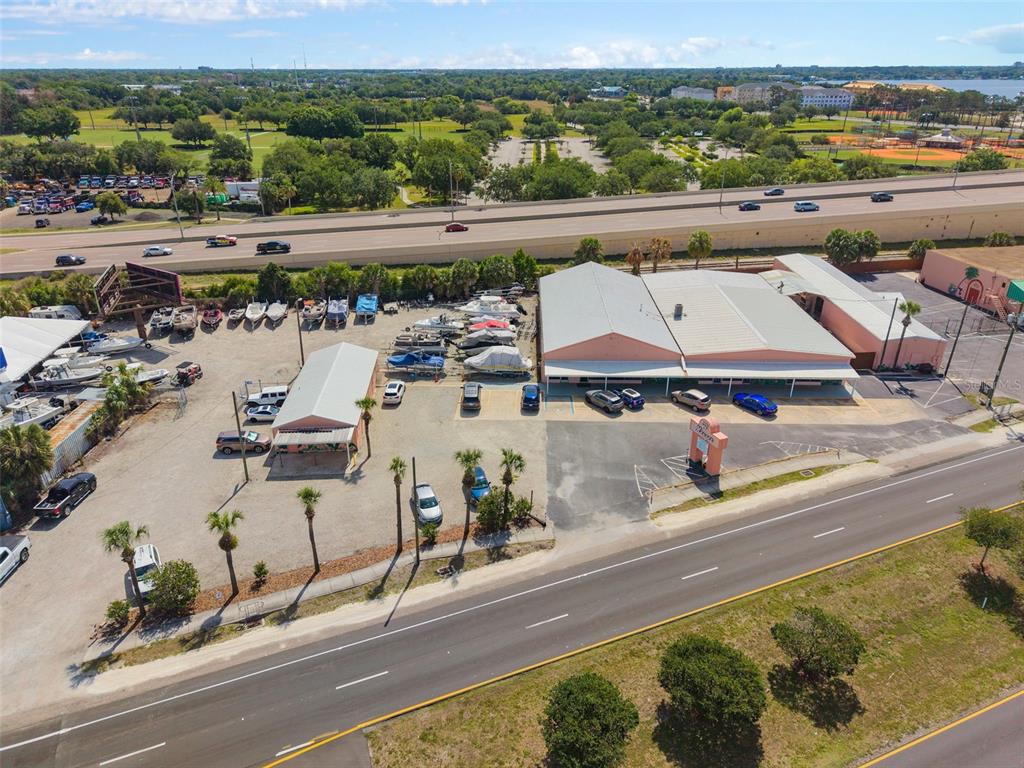 An aerial view shows a commercial property with a large warehouse, parking, and boat storage — 4809 N ORANGE BLOSSOM TRAIL, ORLANDO, FL