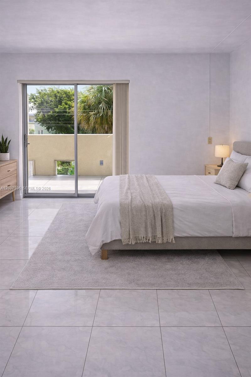 A bedroom features a bed, a rug, tile flooring, and a sliding glass door to a balcony — 7505 SW 82nd St # 322, Miami FL 33143, MIAMI, FL