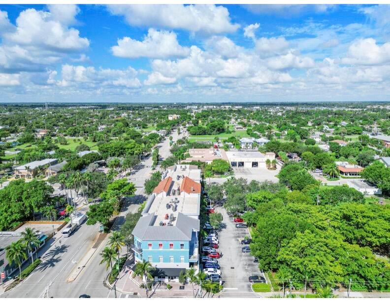 An aerial view shows a blue multi-story commercial building with a parking lot and trees — 401 W Atlantic Avenue # O13, Delray Beach FL 33444, DELRAY BEACH, FL