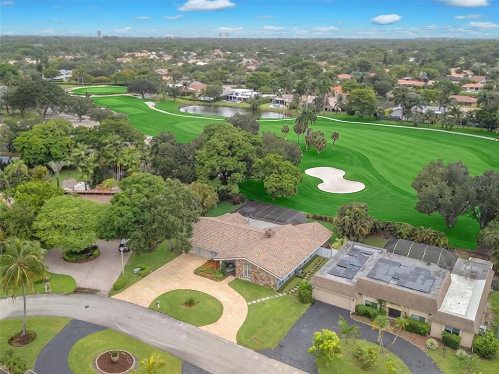 An aerial view shows a single-story house with a pool cage overlooking a golf course — 9651 CONCH SHELL MANOR, PLANTATION, FL