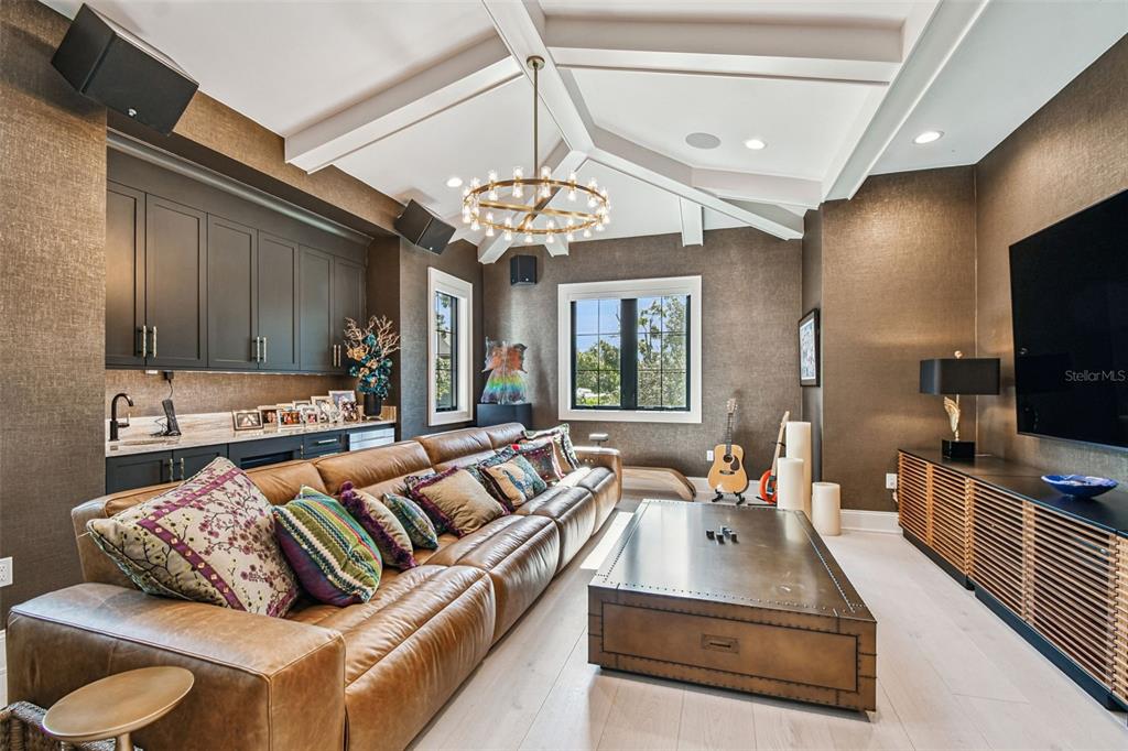 A living room features a large leather sofa, a metal coffee table, and dark cabinetry — 2915 W HARBOR VIEW AVENUE, TAMPA, FL