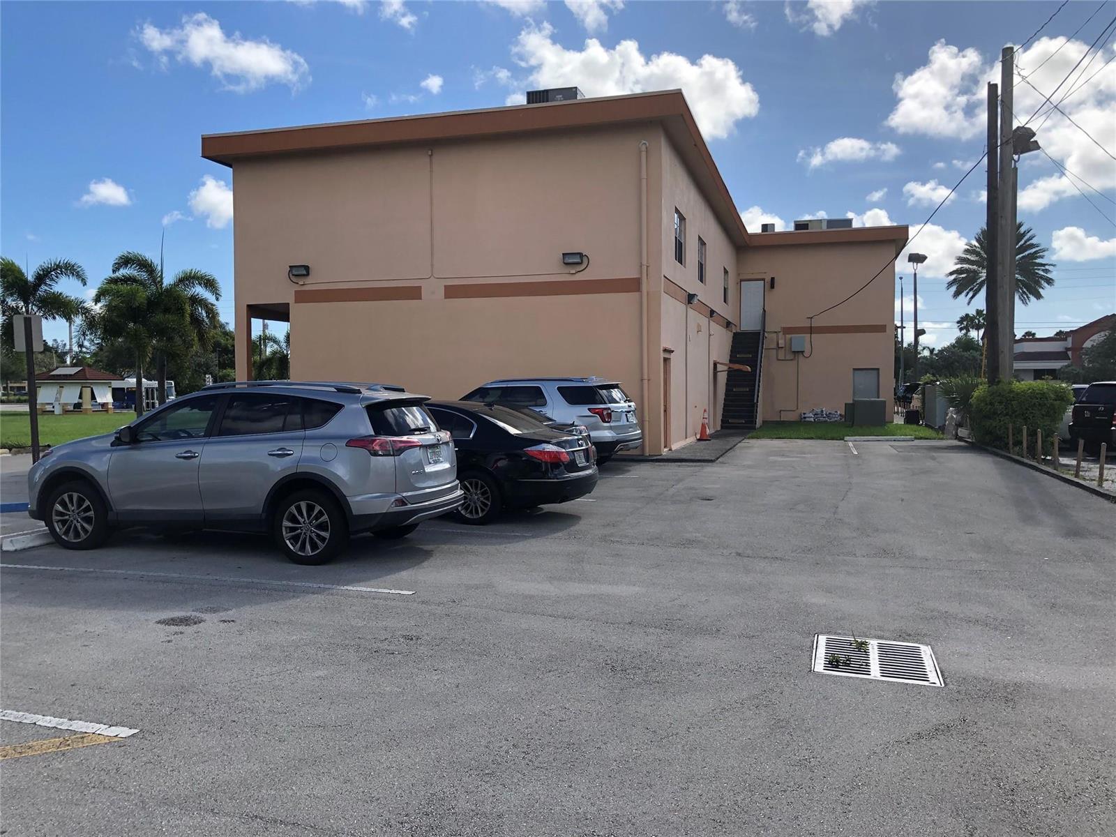 A two-story tan commercial building with a parking lot and outdoor staircase — 1303 N State Road 7 # 6, Margate FL 33063, MARGATE, FL