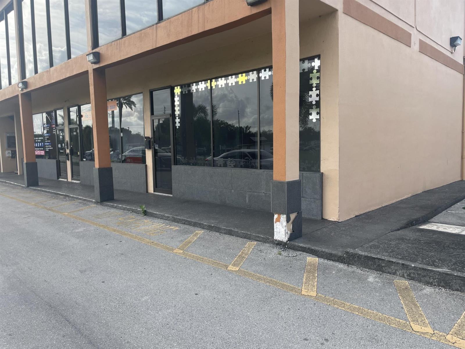 Exterior view of a commercial building storefront with puzzle piece decals on the glass windows — 1303 N State Road 7 # 6, Margate FL 33063, MARGATE, FL