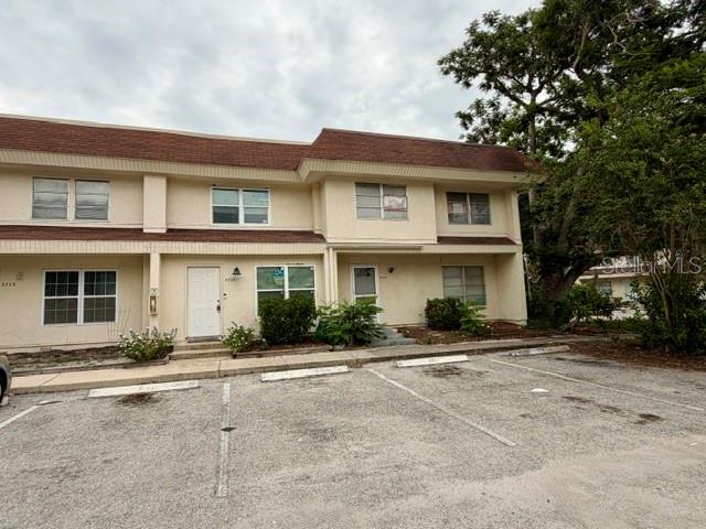 A two-story tan townhouse building with a brown roof and a paved parking lot — 3755 AMHERST WAY UNIT 34, SARASOTA, FL