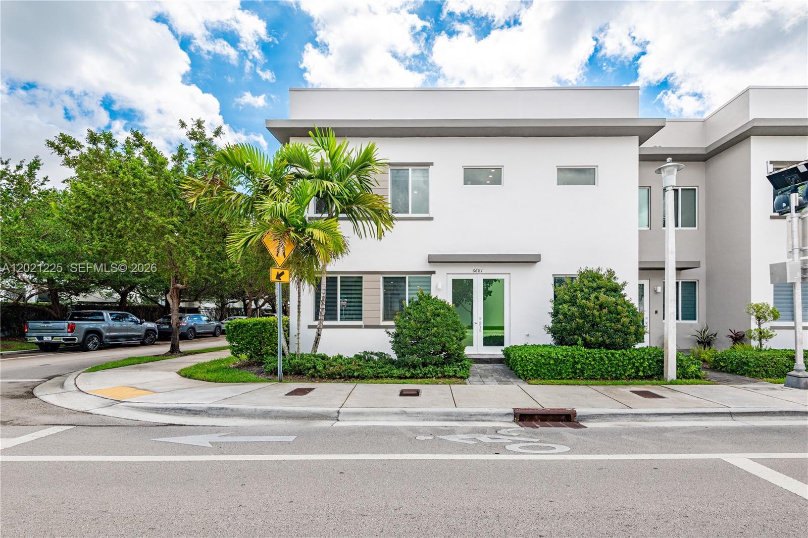 A two-story white modern townhouse features a palm tree and a small landscaped front yard — 6681 NW 104th Ave, Doral FL 33178, DORAL, FL