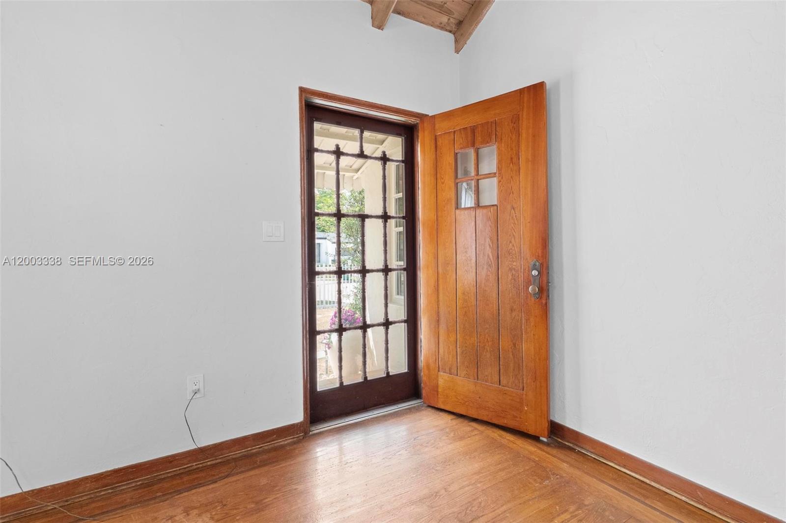 A room with hardwood floors, white walls, and an open wooden door with glass panes — 1879 SW 16th St, Miami FL 33145, MIAMI, FL