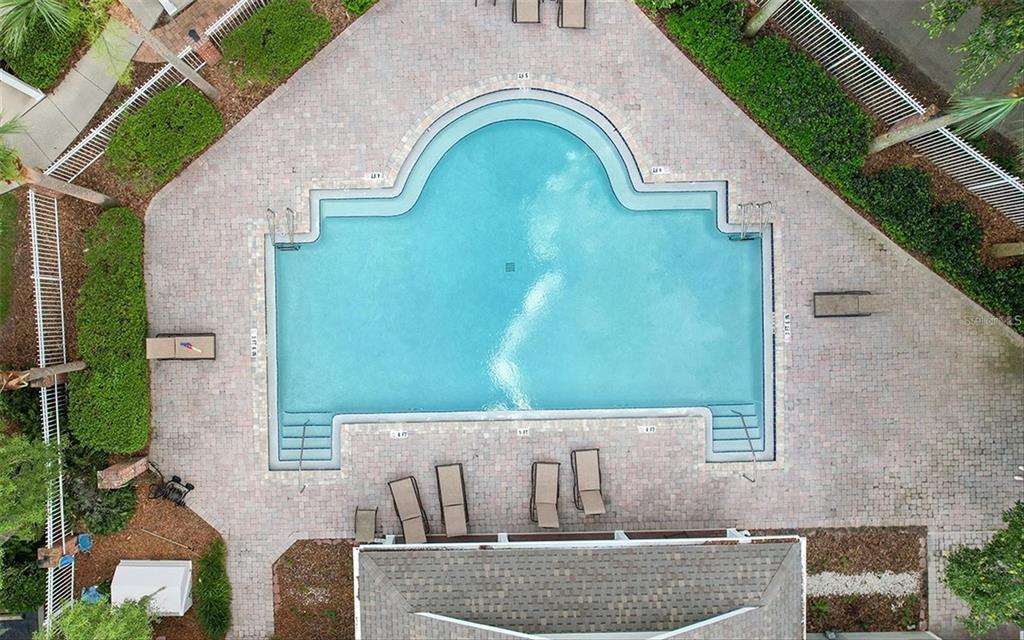 An aerial view shows a swimming pool with a surrounding brick patio and lounge chairs — 10000 SW 52ND AVENUE UNIT EE 183, GAINESVILLE, FL