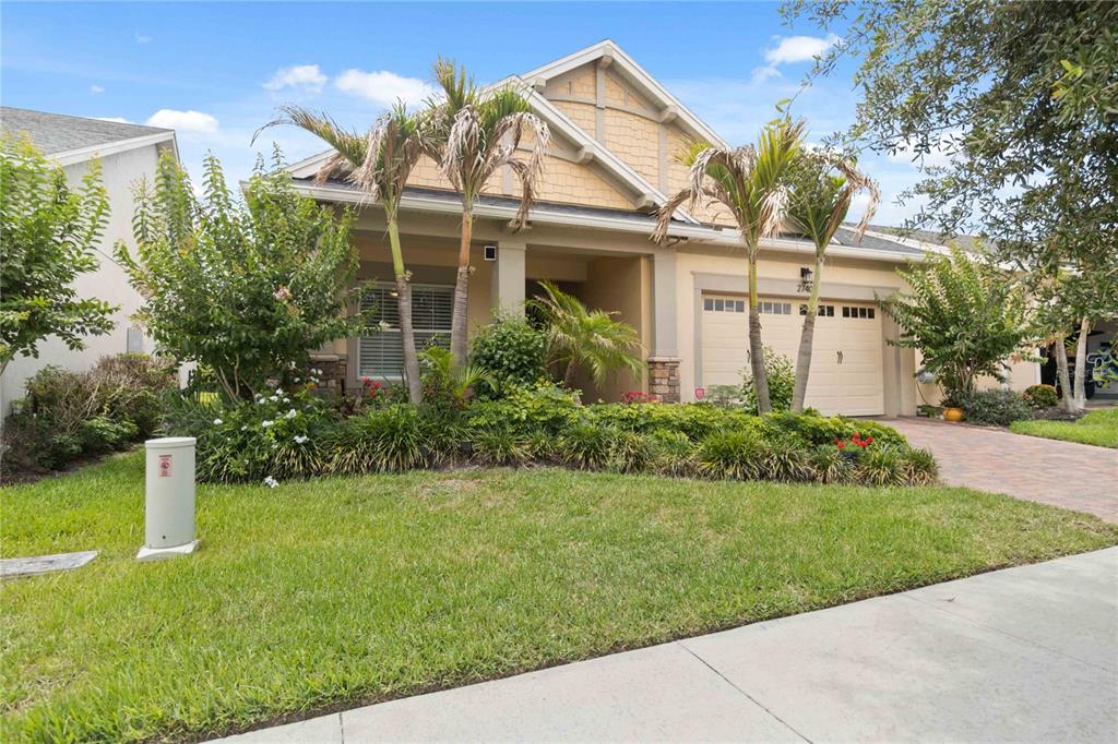 A single-story house with a beige exterior, a two-car garage, and a landscaped front yard — 2740 SOUTHLAND STREET, ST CLOUD, FL