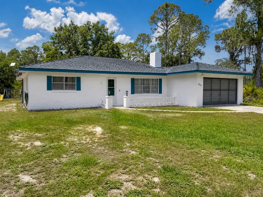 A white brick, single-story house with a dark roof and an attached garage — 3931 GAILLARDIA DRIVE, INDIAN LAKE ESTATES, FL